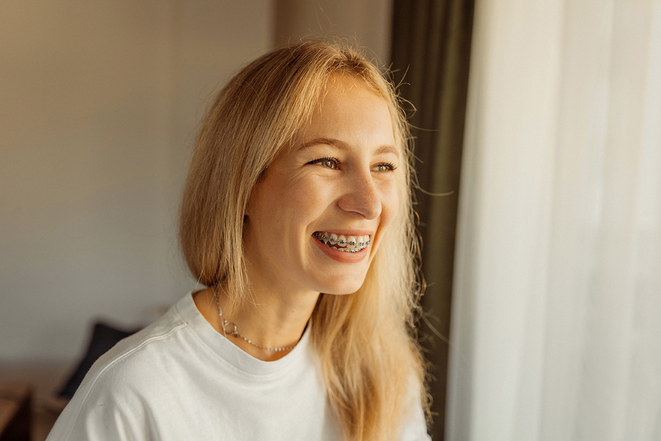 woman smiling with rose gold braces from the smile design